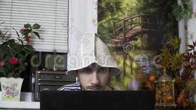 一个穿着背心和浴帽的男人坐在笔记本电脑前，惊讶地睁大眼睛